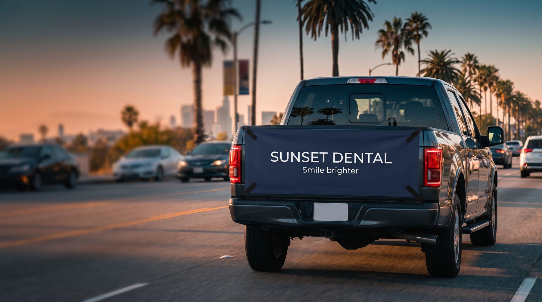 Pickup truck in city traffic with a printed advertising panel on its tailgate